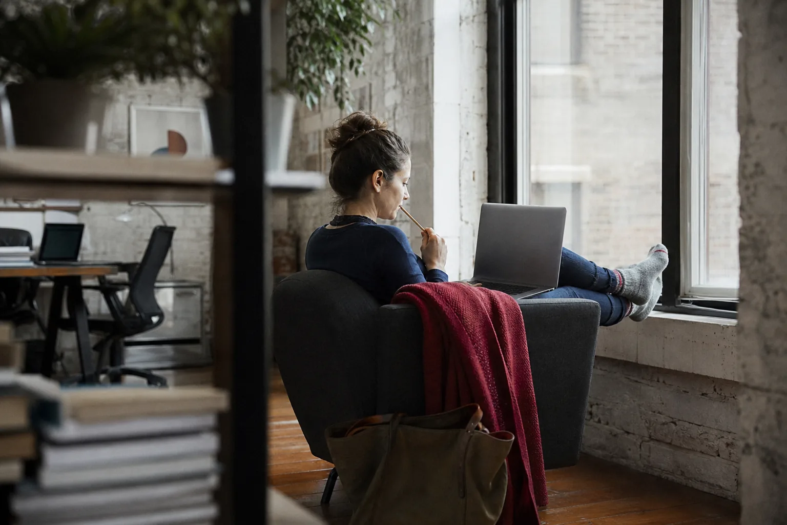 Product marketer thinking through a competitor update on a sofa with a laptop
