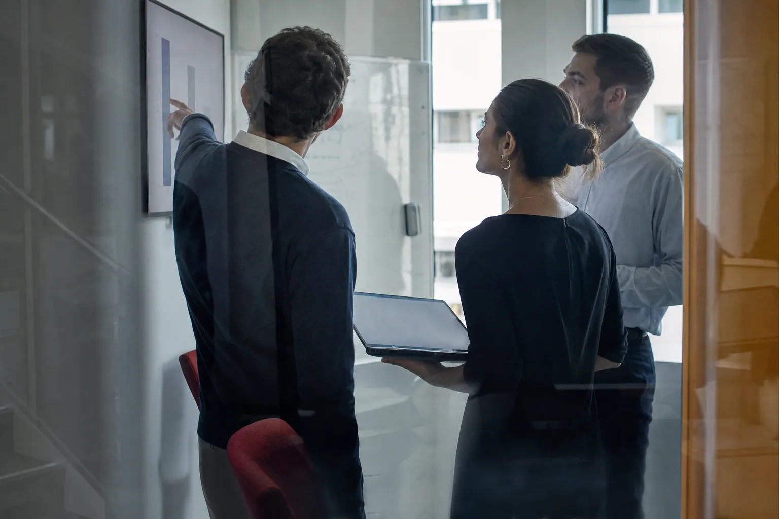 Small team reviewing a dashboard on a wall screen